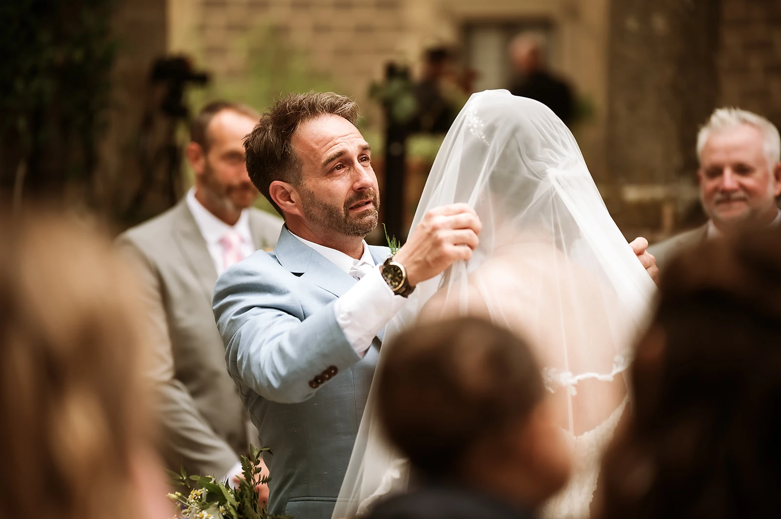 lo sposo emozionato alza il velo della sposa all'inizio della cerimonia