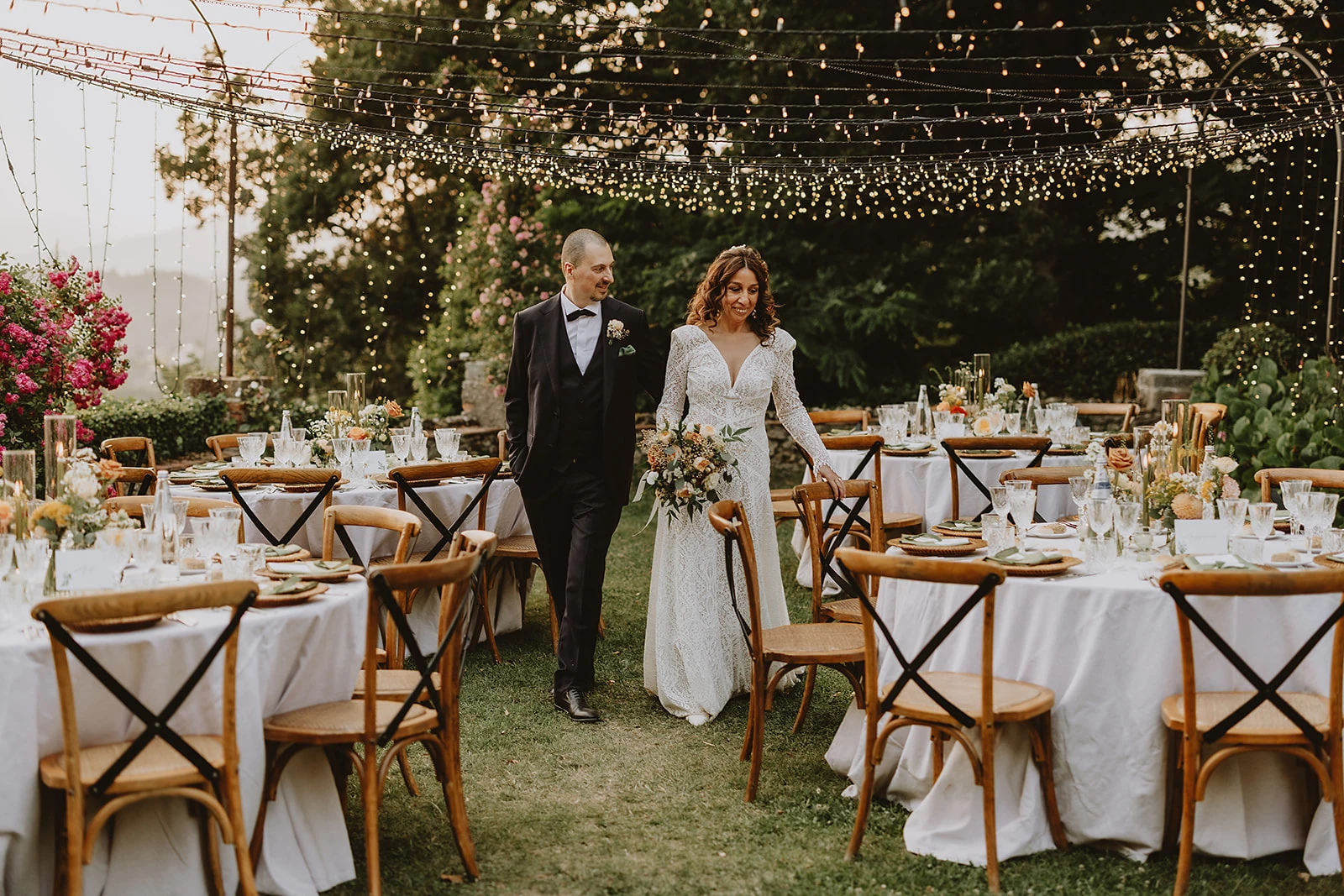 Alessio e raffaella camminano ammirati tra i tavoli del matrimonio coordinato da wedding helper toscana