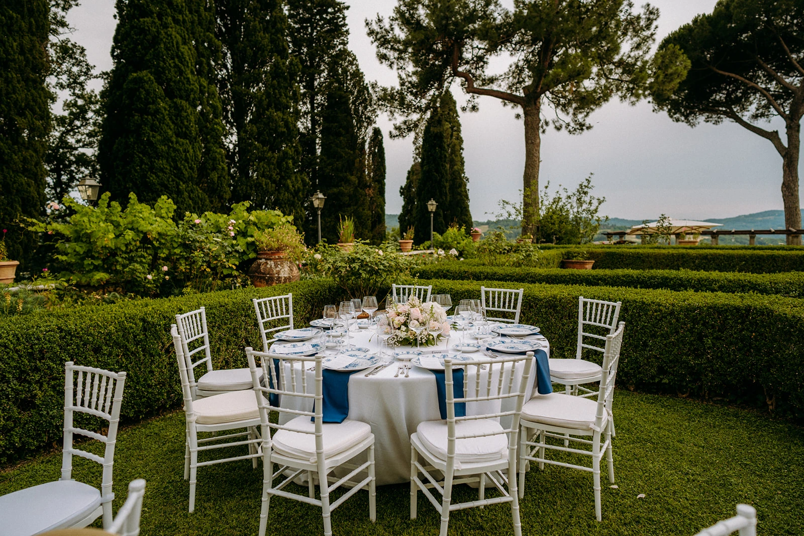 Allestimento dei tavoli del ricevimento di matrimonio nel giardino all'italiana 