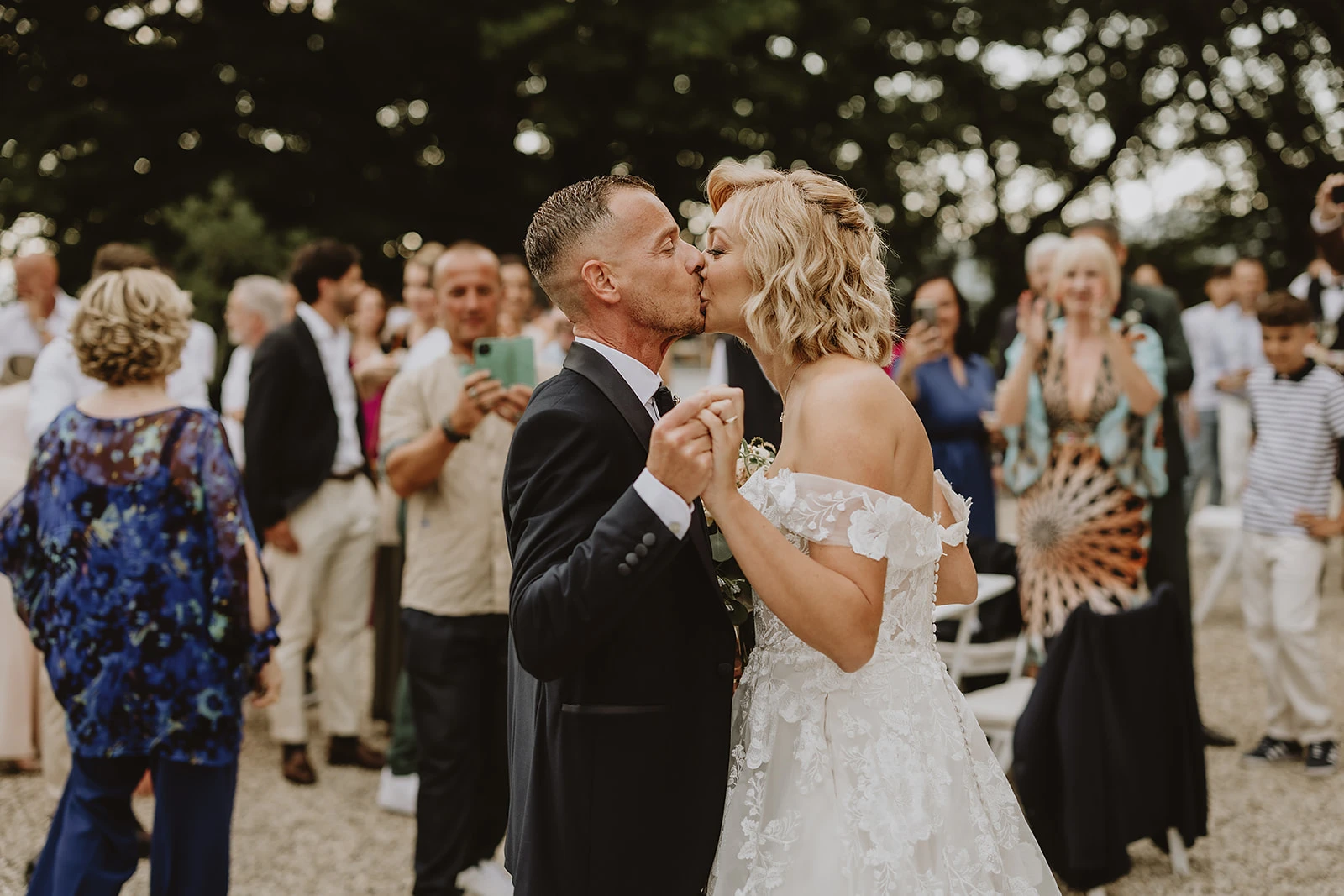 gli sposi si baciano al loro arrivo all'aperitivo di matrimonio in toscana