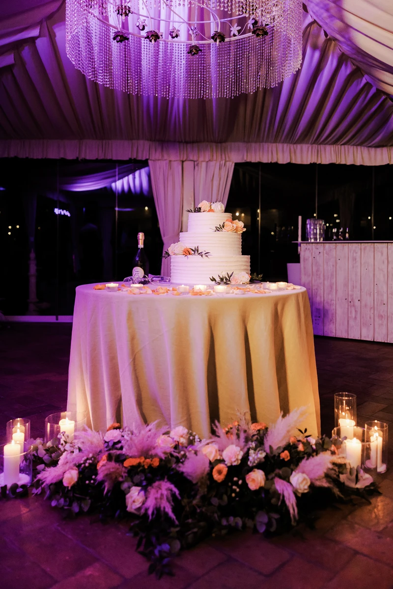 Allestimento del tavolo del taglio della torta con composizioni floreali e candele