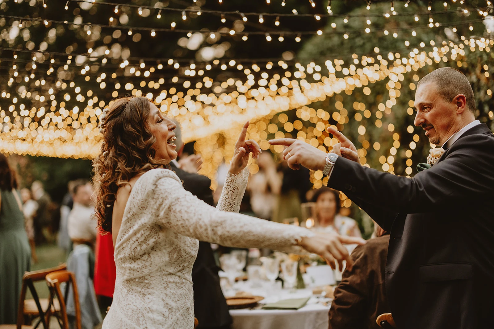 fairy light e sposi che ballano durante la cena nel giardino del glicine di Villa Striano