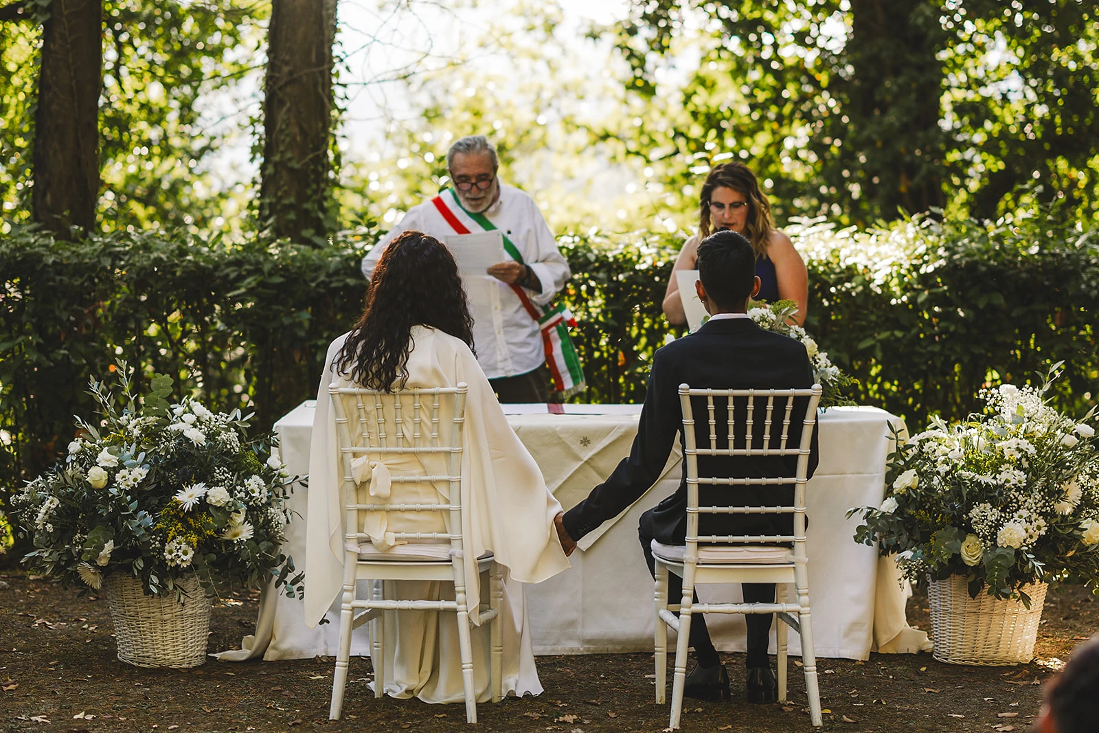 Dettagli della cerimonia con composizioni floreali, Luvai e Jessie matrimonio in toscana